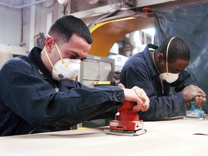 Image of two men sanding wood