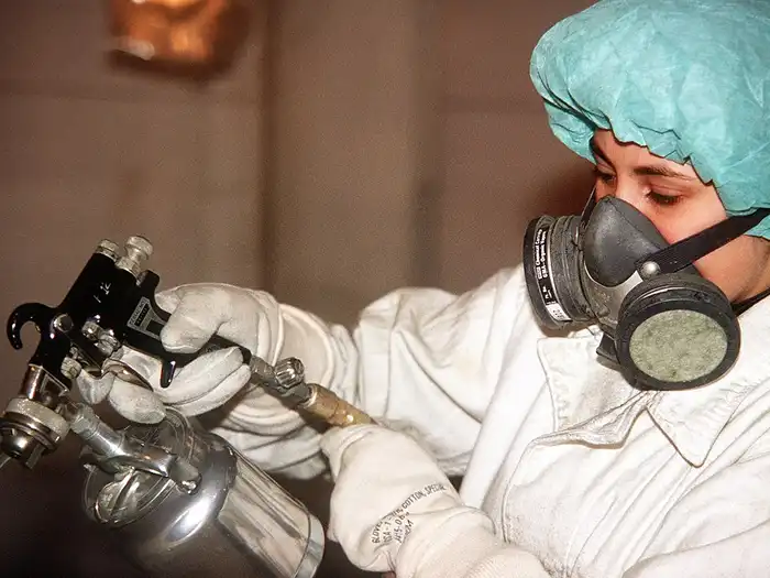 Image of Wearing protective clothing while spray painting
